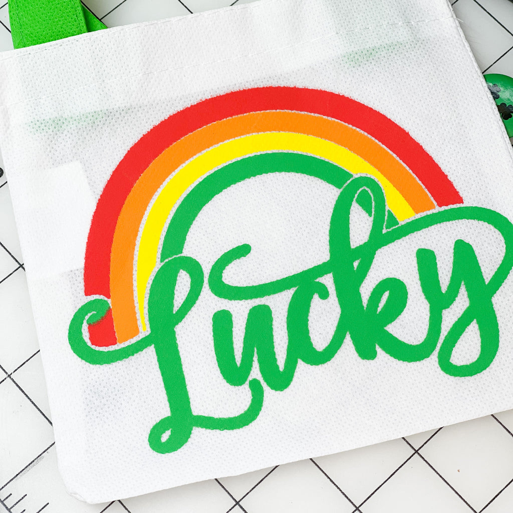 St. Patricks day image of a bag with the word lucky on it and a rainbow above the word 