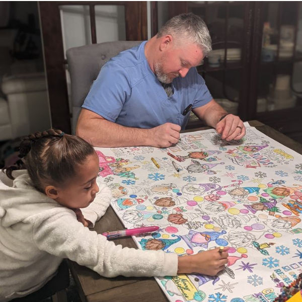 Father and Daughter coloring a giant table top coloring page.