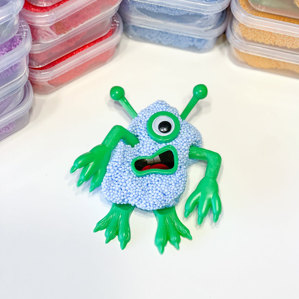 blue and green putty monster with various color putty in the background, children's toys