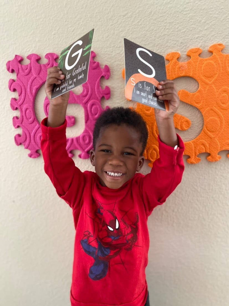 alphabet memory flashcards for kids, educational toys for kids, affirmations for children, child holding two letters above head G and S