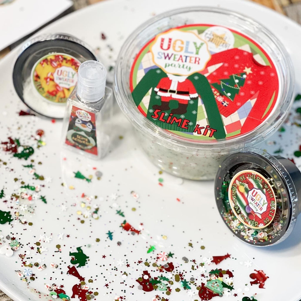 components of christmas slime kit in seperate containers on a plate with confetti, each container has a label 